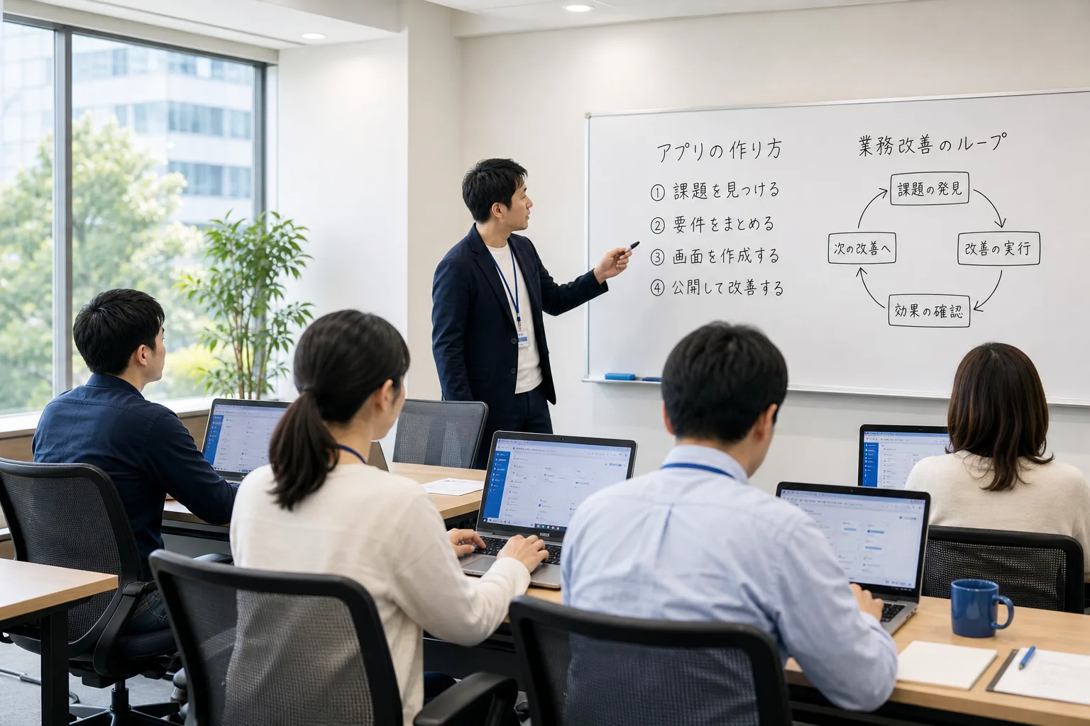 社員がノートPCでアプリを作りながら学ぶ、賑やかな社内勉強会の写真